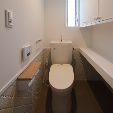 トイレの右手　棚の下はネコ用トイレスペースです<br>床・壁はタイル張り　入り口扉にもネコ用扉を取り付けています<br>ねこさんがお好きな水の流れるタンク付便器です