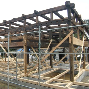 新たに設けた鉄筋コンクリート製の基礎の上に　補修の済んだ木材を再び組み上げていきます