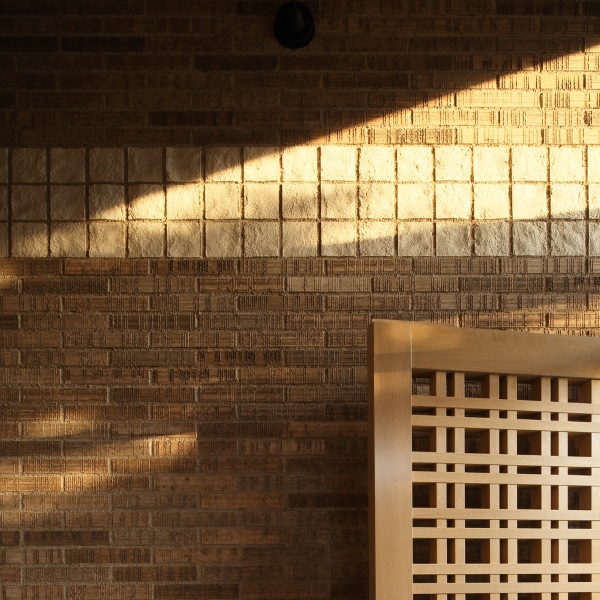 アプローチのタイル壁面に斜めに陽が差し込んでいます