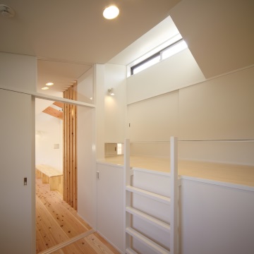 造り付けのベッドの上部には高窓　枕元にはリビングを覗く小窓があります
